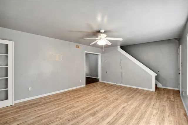 a view of an empty room with wooden floor