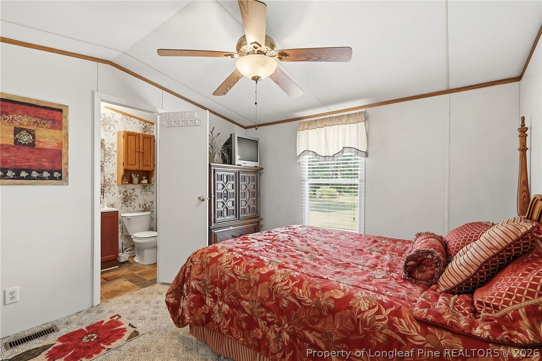 10400 Ruth Vinson Road Autryville, NC 28318 - Photo 44 of 49 a bedroom with a bed and a chandelier