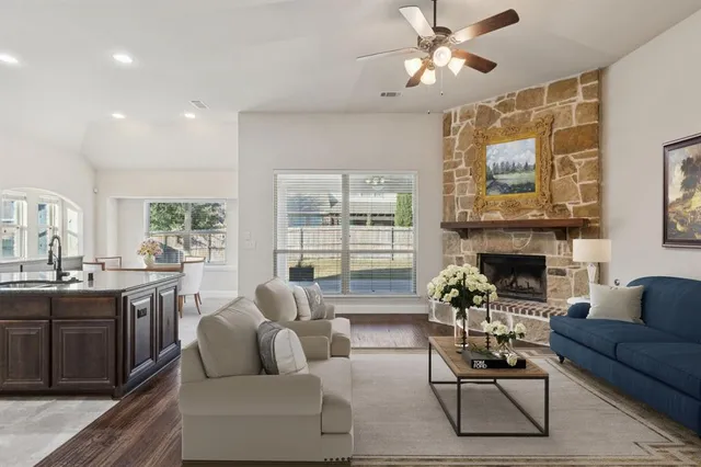 a living room with furniture a large window and a fireplace