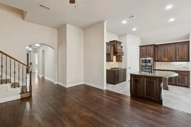 a kitchen with stainless steel appliances wooden floors and wooden cabinets