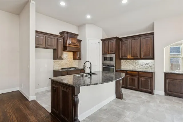 a kitchen with stainless steel appliances granite countertop a sink stove and refrigerator