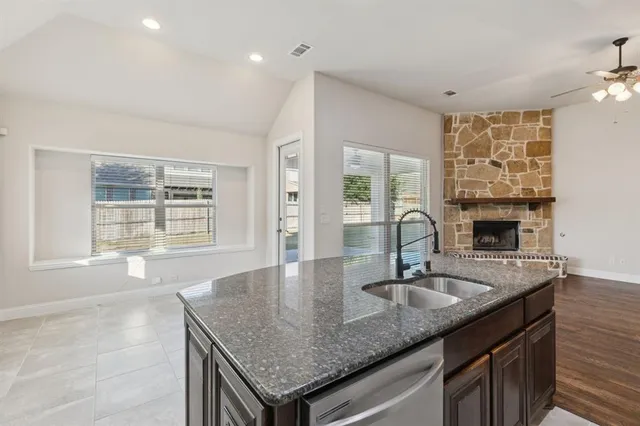 a kitchen with granite countertop a sink cabinets and window