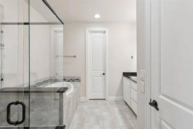 a bathroom with a granite countertop sink a mirror and a shower