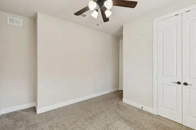 an empty room with a chandelier fan