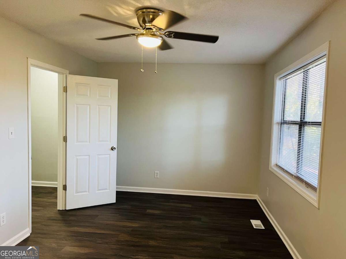 5614 Windwood Road, Unit 5614 Atlanta, GA 30349 - Photo 15 of 26 a view of an empty room with wooden floor and a window