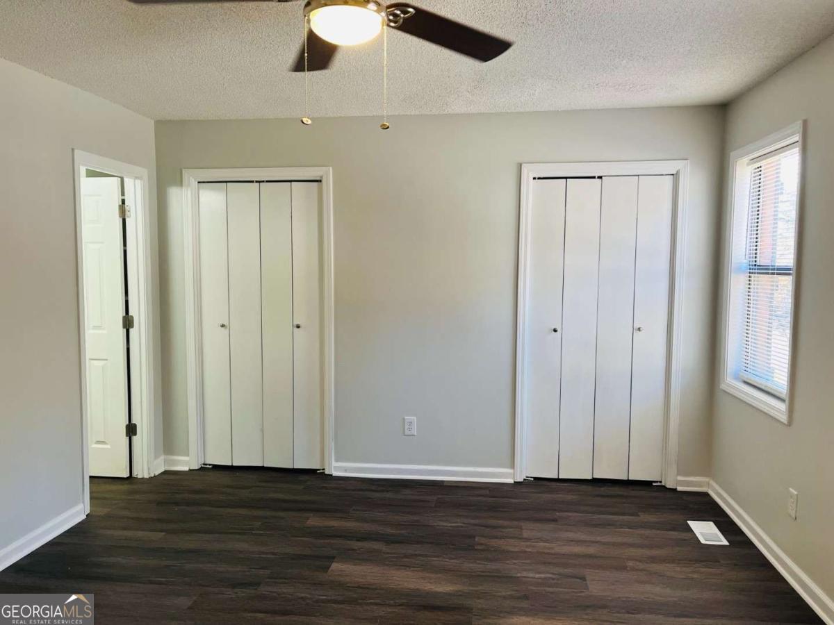 5614 Windwood Road, Unit 5614 Atlanta, GA 30349 - Photo 20 of 26 an empty room with wooden floor cabinet and windows