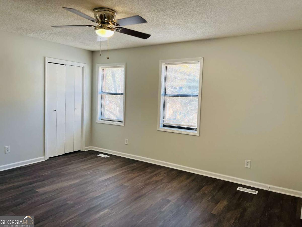 5614 Windwood Road, Unit 5614 Atlanta, GA 30349 - Photo 7 of 26 a view of an empty room with wooden floor and a window