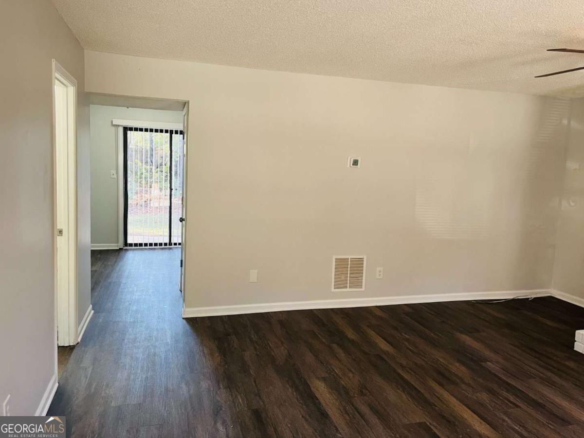 5614 Windwood Road, Unit 5614 Atlanta, GA 30349 - Photo 10 of 26 a view of a room with wooden floor and white walls