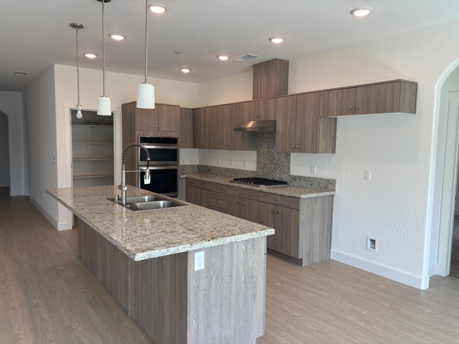 3808 Via Capitola Madera, CA 93637 - Photo 2 of 8 a kitchen with kitchen island stainless steel appliances a sink and counter space
