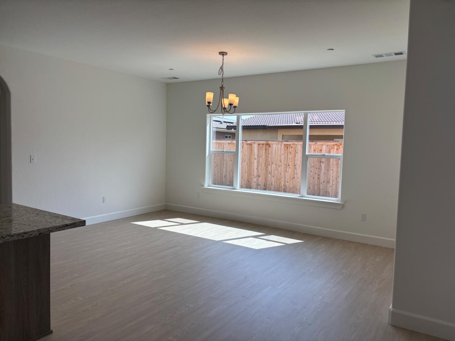 3808 Via Capitola Madera, CA 93637 - Photo 4 of 8 an empty room with windows and chandelier