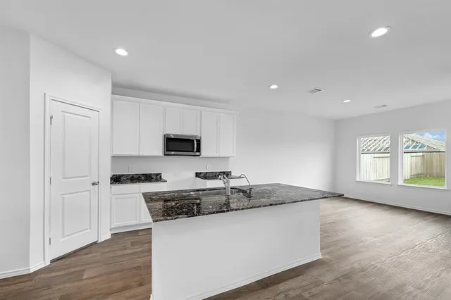 a kitchen with stainless steel appliances granite countertop a stove a sink and a microwave