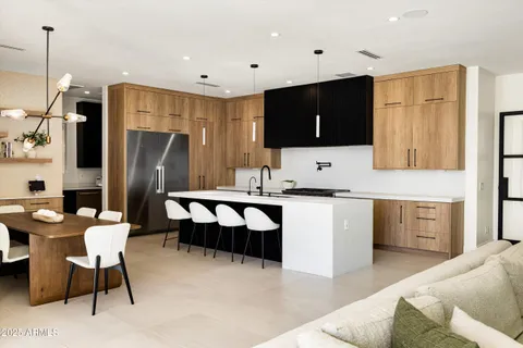 a large kitchen with stainless steel appliances kitchen island granite countertop a refrigerator and a stove top oven