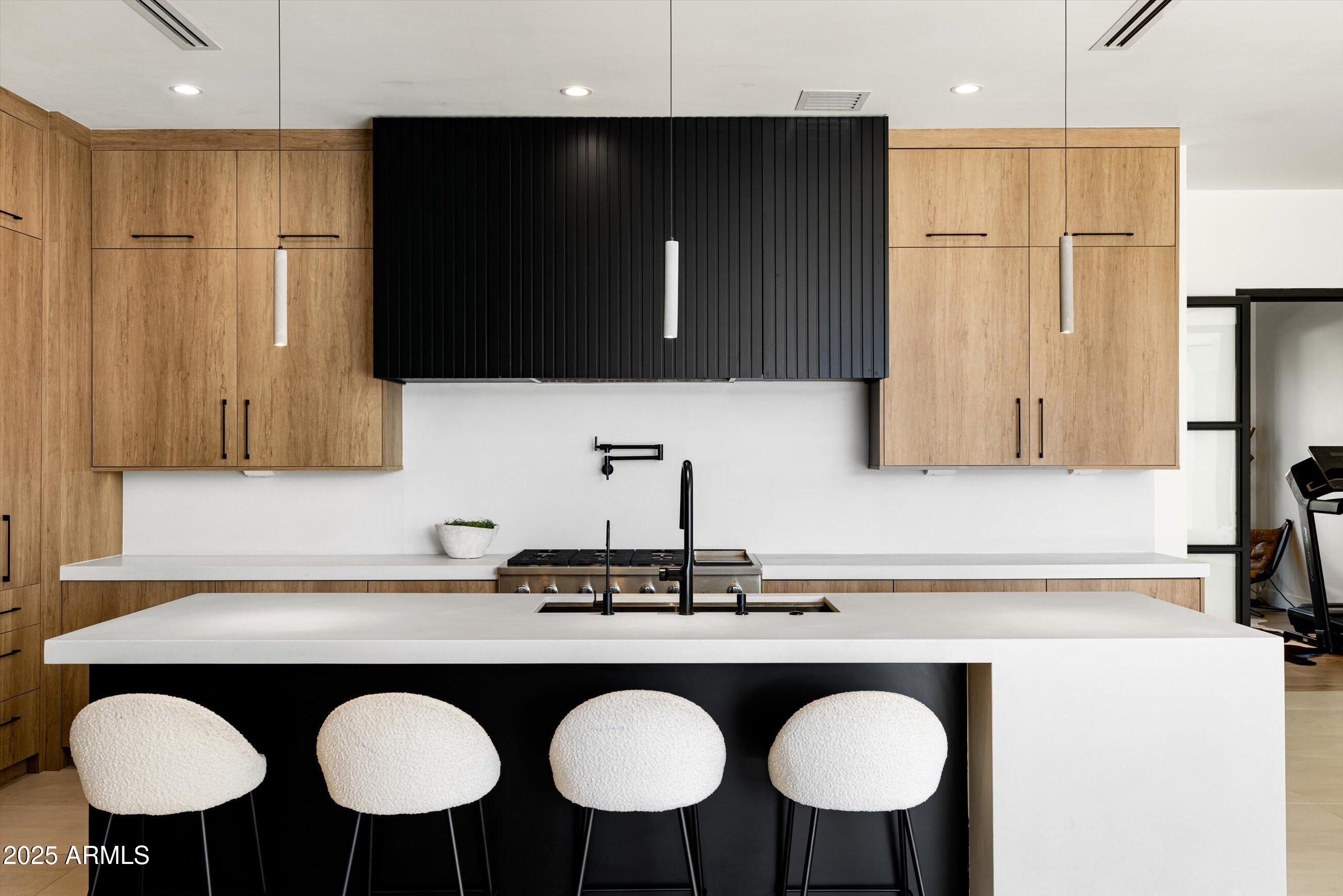 3721 East Piccadilly Road Phoenix, AZ 85018 - Photo 14 of 54 a kitchen with stainless steel appliances granite countertop a sink a microwave a stove and white cabinets