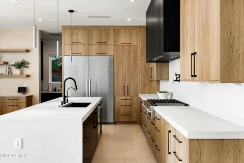 a kitchen with stainless steel appliances granite countertop a sink a microwave a stove and white cabinets