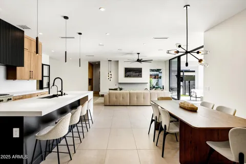 a kitchen with kitchen island a dining table chairs stainless steel appliances and cabinets