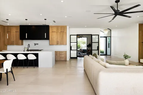 a kitchen with kitchen island a dining table chairs and white cabinets
