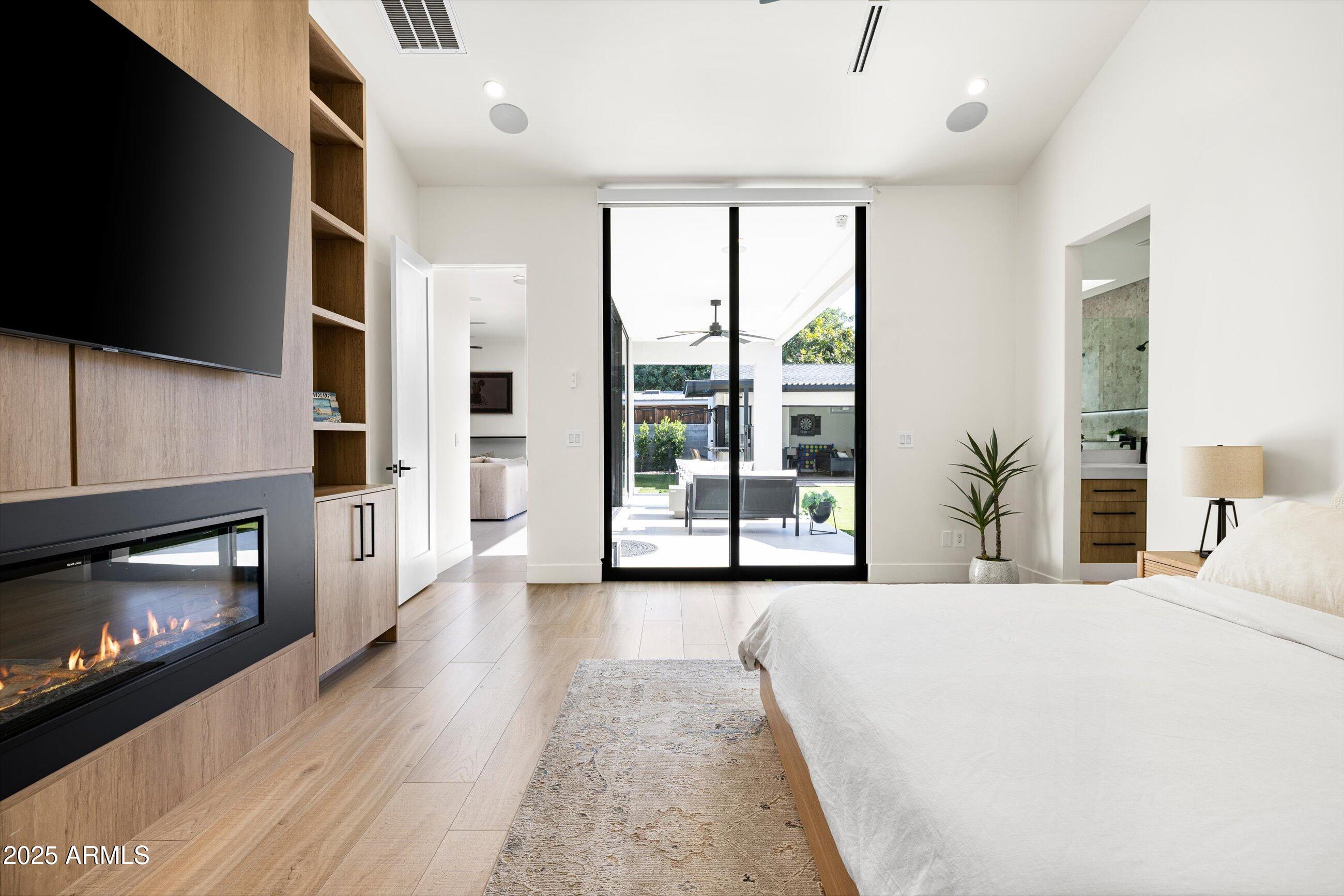 3721 East Piccadilly Road Phoenix, AZ 85018 - Photo 23 of 54 a bedroom with furniture a flat screen tv and a fireplace