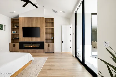 a bedroom with furniture a flat screen tv and a fireplace