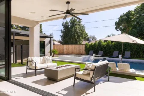 a view of a house with backyard swimming pool and sitting area