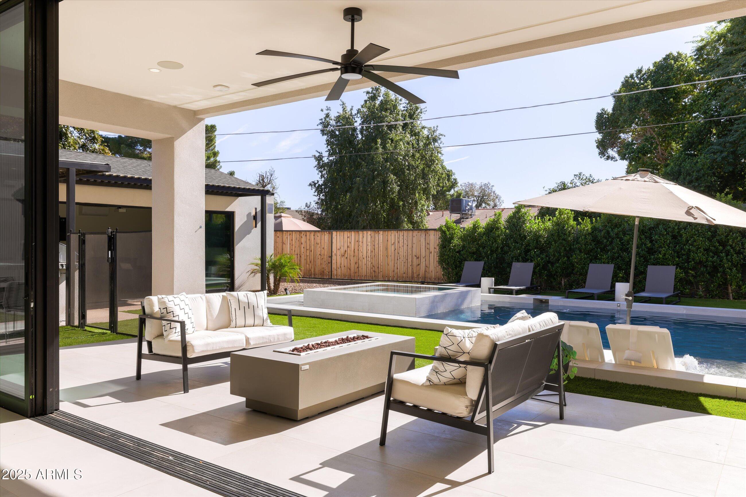 3721 East Piccadilly Road Phoenix, AZ 85018 - Photo 37 of 54 a view of a patio with couches table and chairs under an umbrella