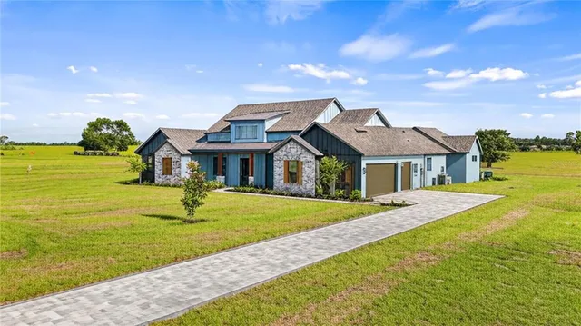 a front view of house with yard and ocean