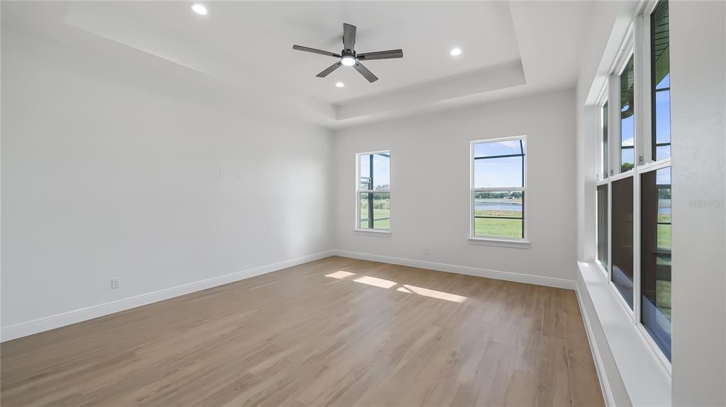 20130 Sugarloaf Mountain Road Clermont, FL 34715 - Photo 4 of 18 an empty room with wooden floor fan and windows