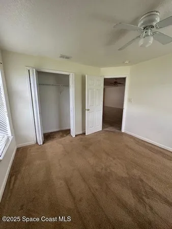an empty room with a bathroom and mirror