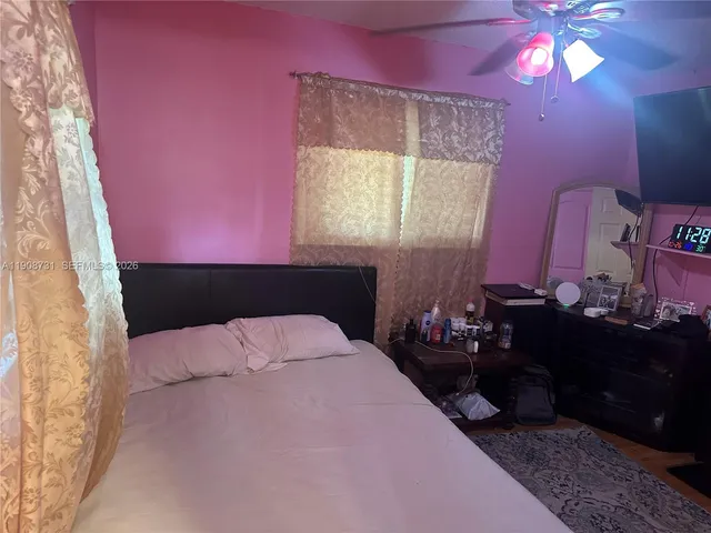 a bedroom with a bed window and mirror