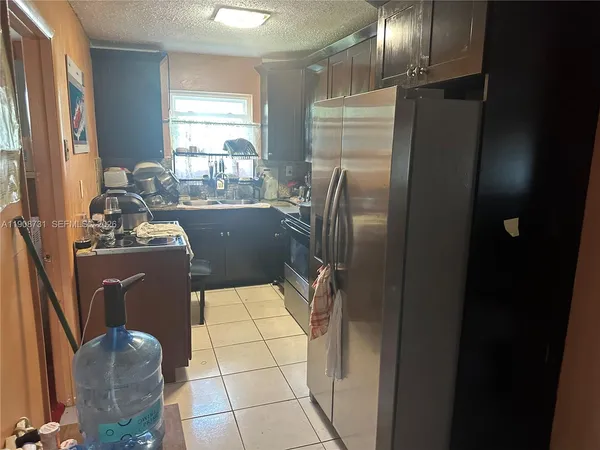 a view of a hallway with workspace and a refrigerator