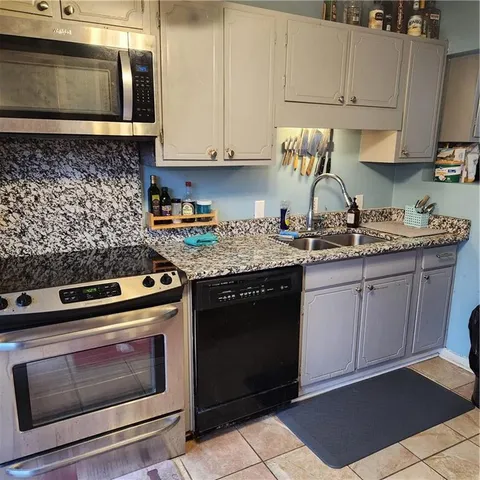 a kitchen with stainless steel appliances a stove a sink and a microwave