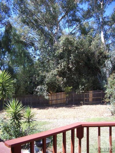 1235 Foothill Road Ojai, CA 93023 - Photo 8 of 8 a view of backyard with wooden fence and large trees