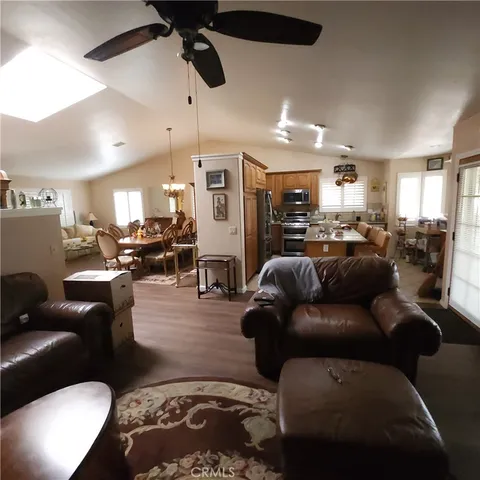 a living room with furniture kitchen view and a chandelier