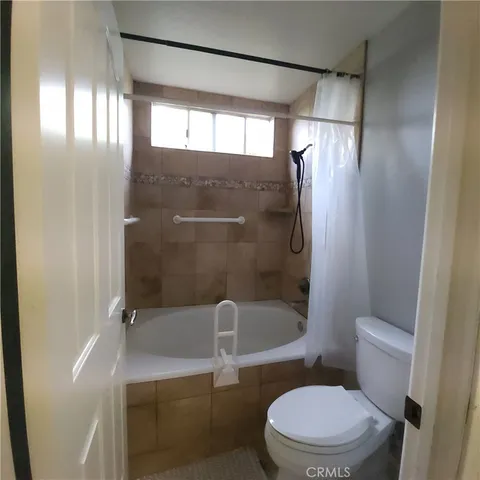 a white toilet sitting next to a bath tub and shower