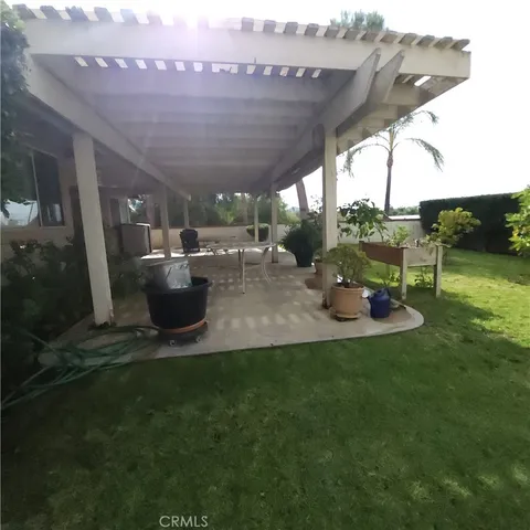 a view of a patio with table and chairs potted plants with floor to ceiling window
