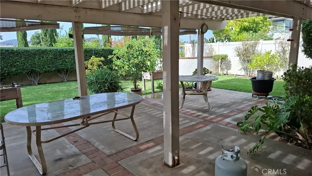 a view of a patio with a table chairs and a backyard