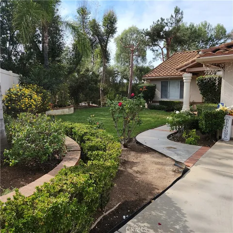 a front view of a house with a yard and potted plants