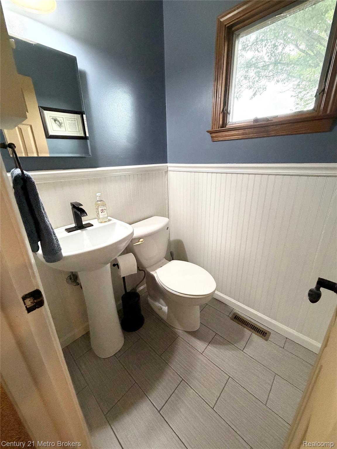 3259 North Seymour Road Flushing, MI 48433 - Photo 33 of 49 Pedestal sink with matte black faucet, complemented by white beadboard wainscoting