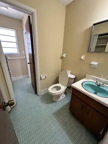 a bathroom with a sink mirror vanity and toilet