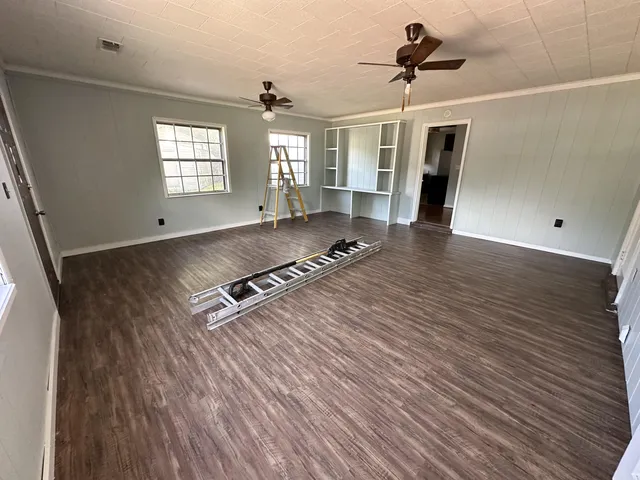 a living room with hard wood floors and a window