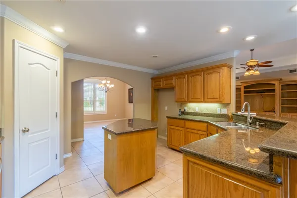 a kitchen with stainless steel appliances granite countertop a sink a stove and a refrigerator