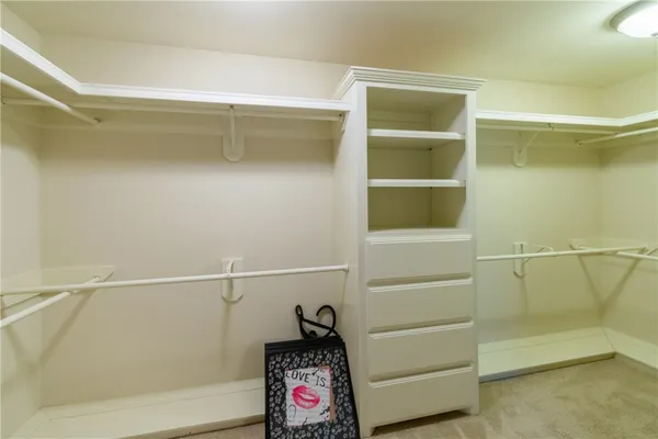 a view of walk in closet with empty racks