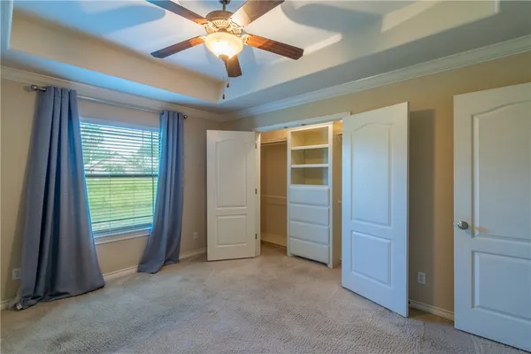 an empty room with ceiling fan and window