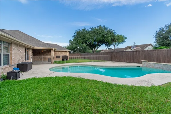 a view of swimming pool with lawn chairs and plants