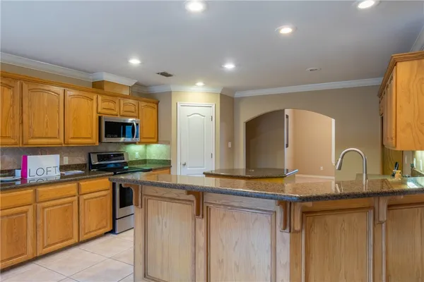 a kitchen with stainless steel appliances granite countertop a stove a sink and a microwave
