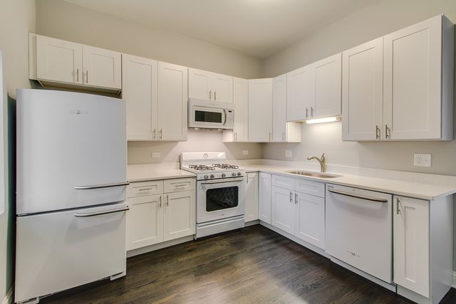 a kitchen with white cabinets and white appliances