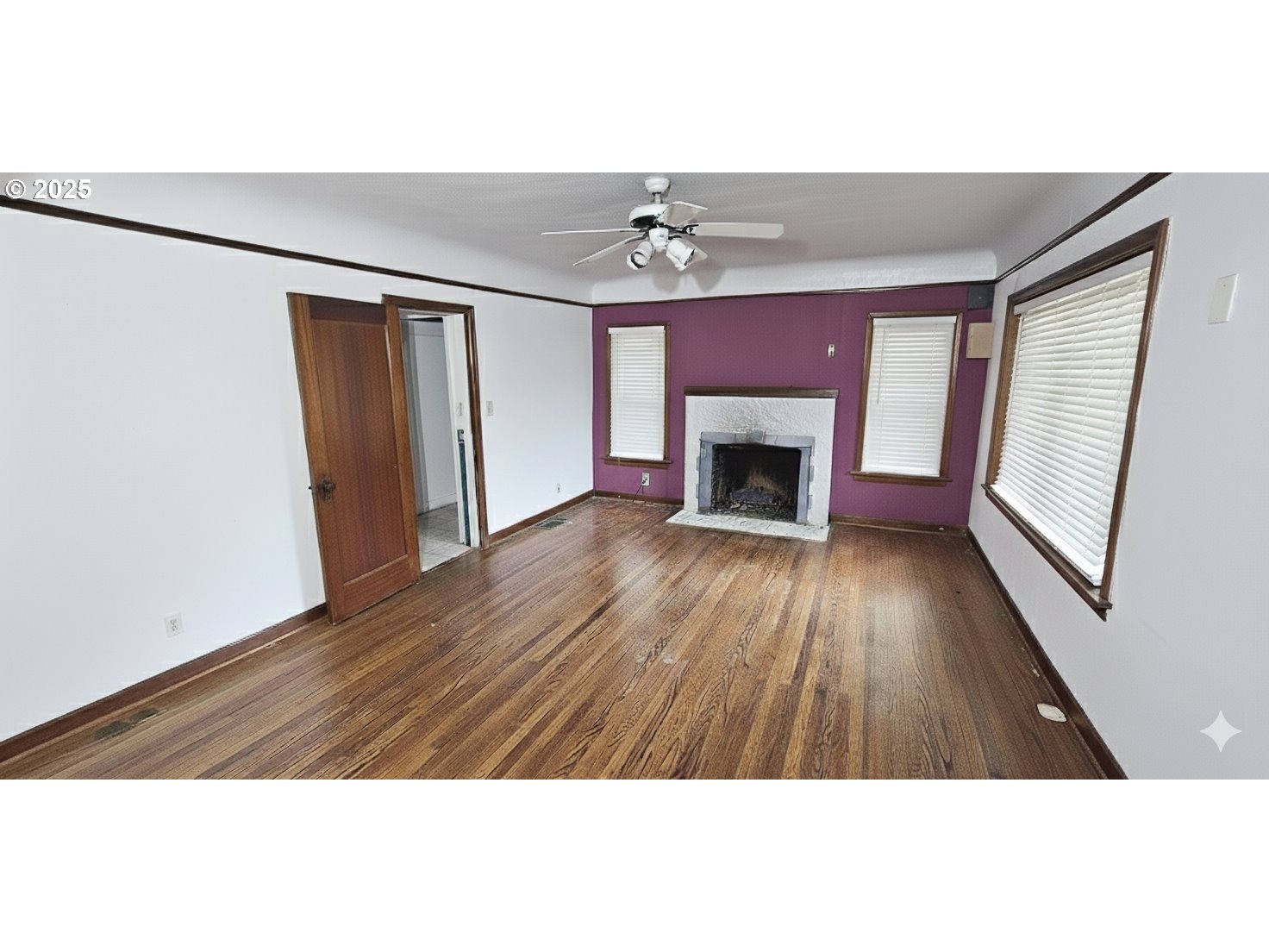 5836 Northeast Halsey Street Portland, OR 97213 - Photo 3 of 12 a view of an empty room with wooden floor fireplace and a window