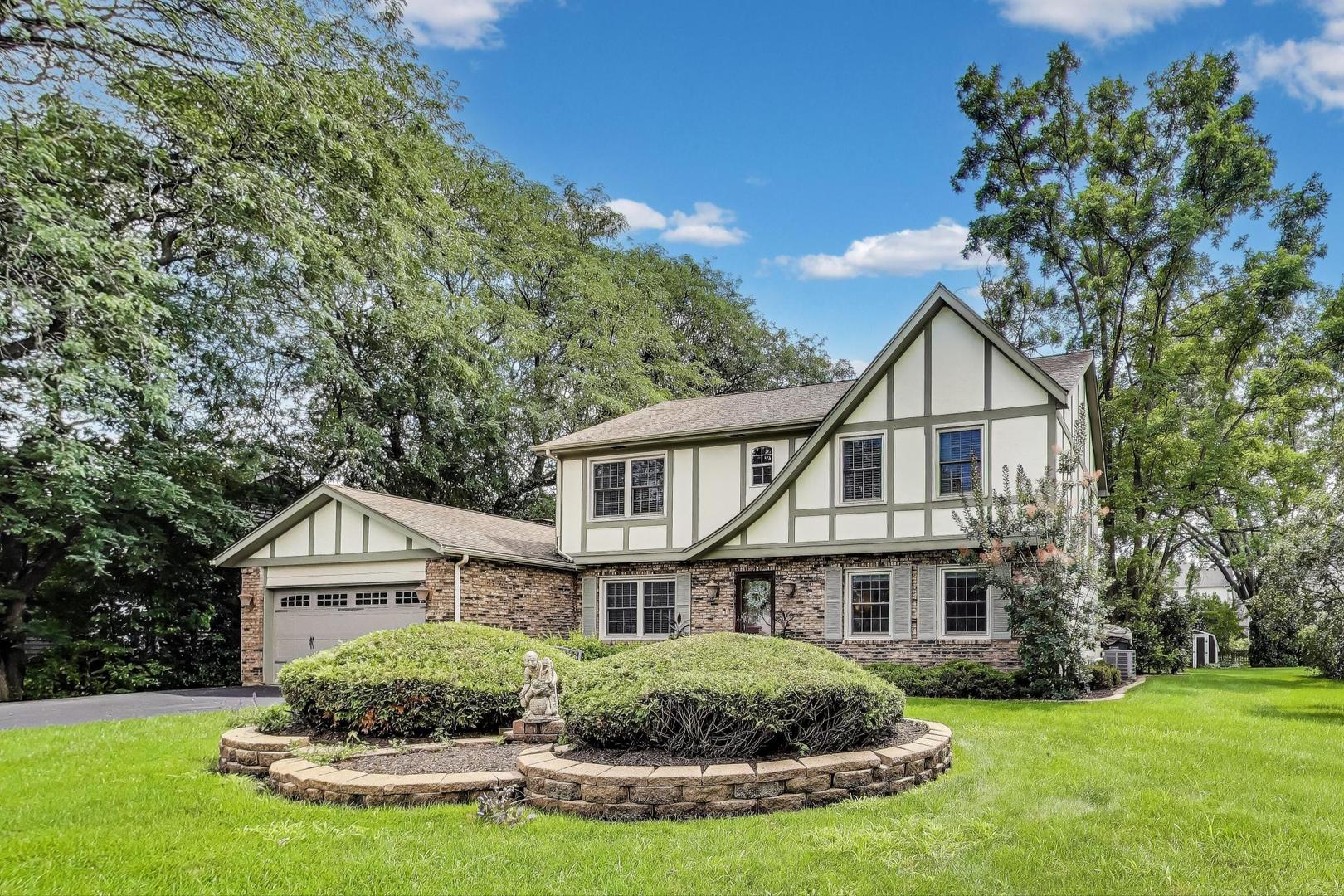 28W409 Leverenz Road Naperville, IL 60564 - Photo 1 of 39 a house that is sitting in the grass with large trees and plants