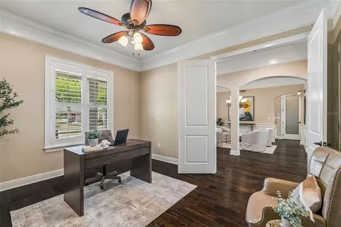 a dining room with furniture potted plants and wooden floor