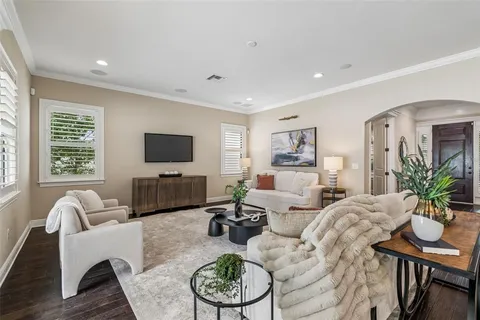 a dining room with wooden floor a chandelier a glass table and chairs