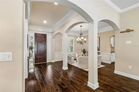 a kitchen with stainless steel appliances kitchen island granite countertop a refrigerator a stove a oven and white cabinets with wooden floor